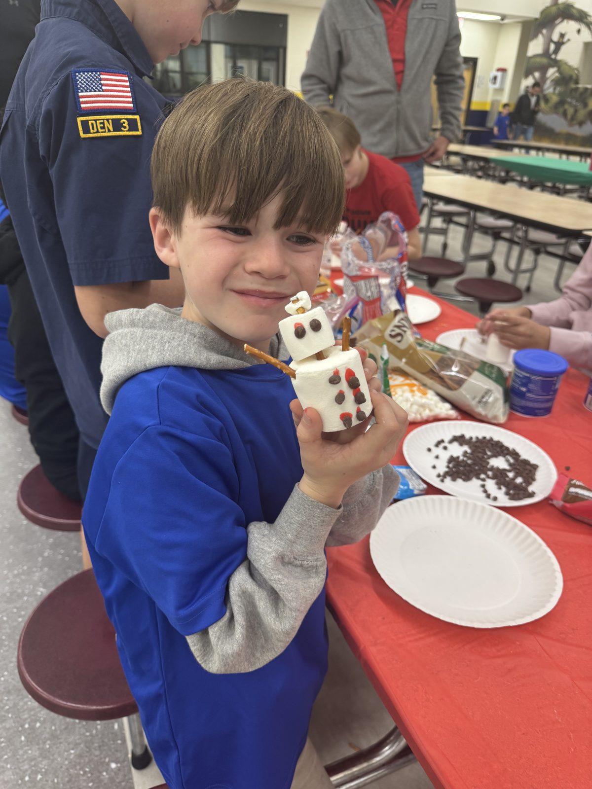 A scout showing off a marshmallow craft at a den meeting